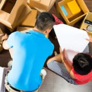 Image of a couple packing boxes to move